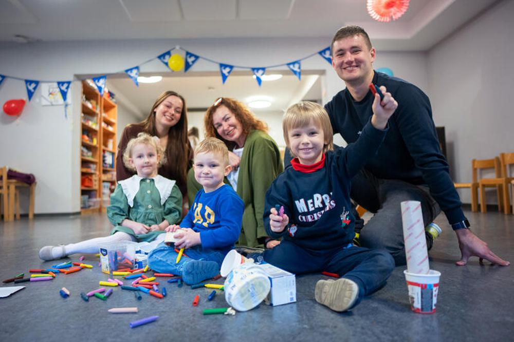 Erzieherinnen Alisa Hniedo, Iryna Khudenko und Andrii Kazmirchuk (oben v.li.) mit Kindern.