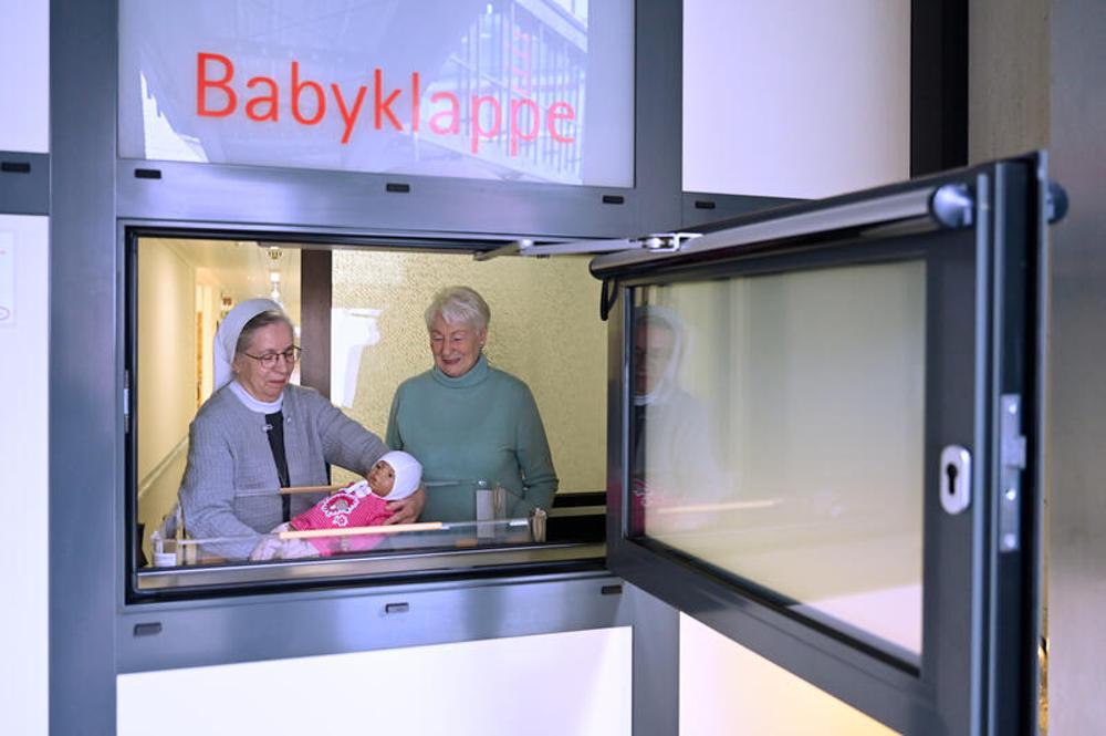 Schwester Annette Biecker (l.) und Marion Meister mit einer Puppe an der Babyklappe am St. Vinzenz-Krankenhaus in Hanau