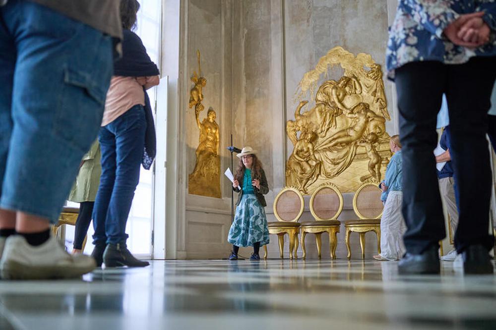 Lila Riedel (Mitte) bei einer Führung im Schloss Neue Kammern im Park Sanssouci in Potsdam