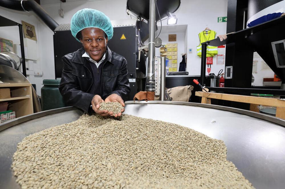 Fokam Fobissie zeigt die noch unger&ouml;steten Arabica-Kaffeebohnen aus Uganda.
