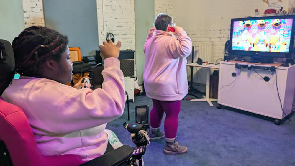 Zwei Mitarbeitende des inklusiven Projekts "barner16" in Hamburg spielen "Just Dance"