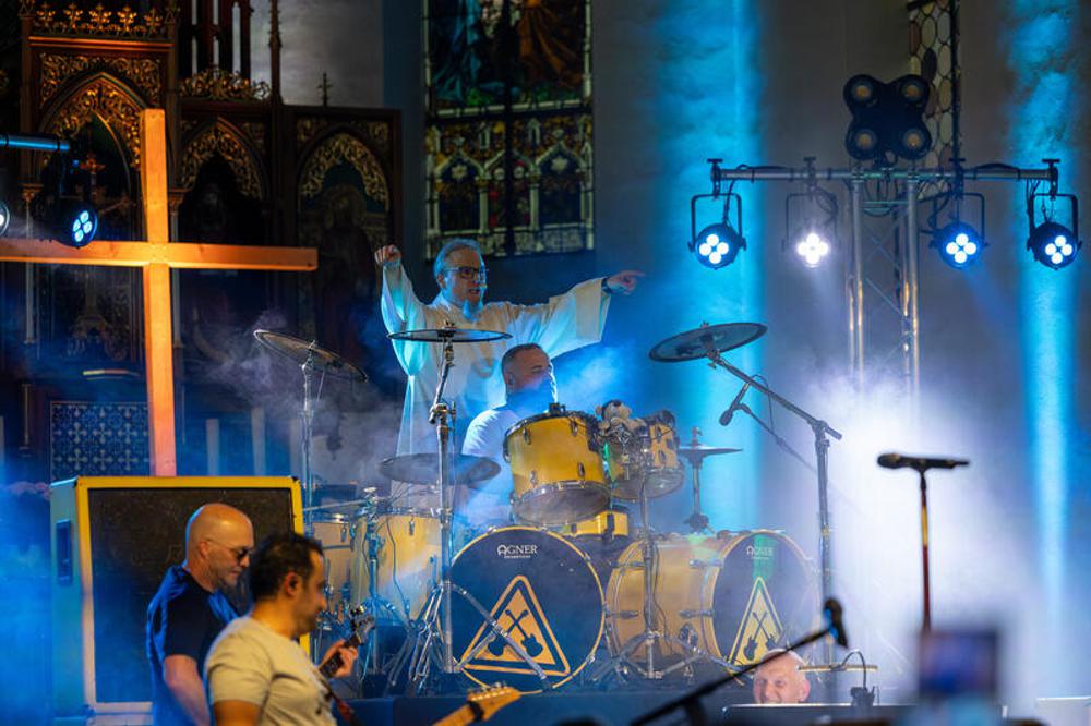 Pastoralreferent Mathias Fuchs (hinten) bei einem Heavy-Metal-Gottesdiens mit der Band "Metal Godz"